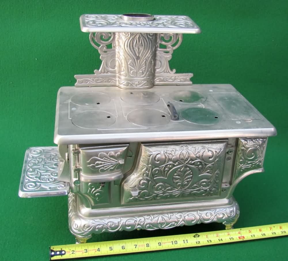 Sold at Auction: Two Miniature Cast Iron Stoves and Pans